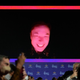 An image of Elon Musk looking red with a black background is shown.